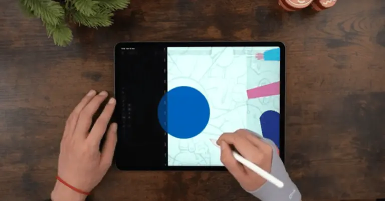 Male hands drawing on an iPad positioned on a wooden table
